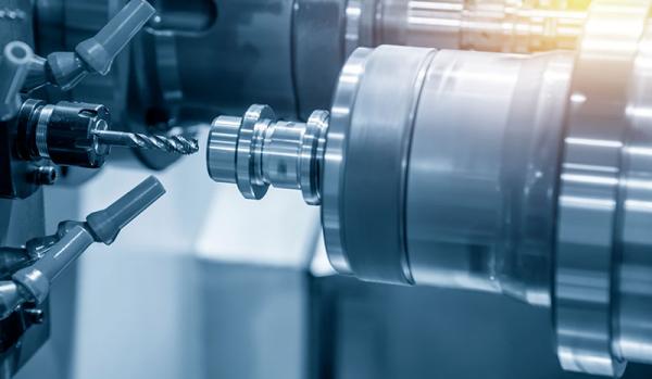 The CNC lathe machine making the thread  at the steel shaft by tapping tool .Hi-technology automotive part manufacturing process.