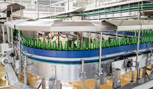 Inside of beverage industry automatic machine with product line of red juice for packaging
